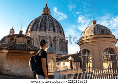 Tourist man with detailed close up view on Michelangelos Dome of St Peter Basilica in Vatican City, Rome, Lazio, Europe, EU. Architectural masterpiece of Papal Basilica of Saint Peter on sunny day Royalty-Free Stock Photo #2282936629