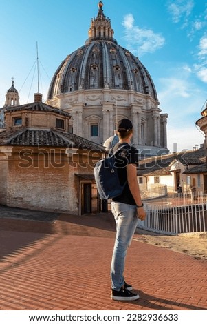 Tourist man with detailed close up view on Michelangelos Dome of St Peter Basilica in Vatican City, Rome, Lazio, Europe, EU. Architectural masterpiece of Papal Basilica of Saint Peter on sunny day Royalty-Free Stock Photo #2282936633