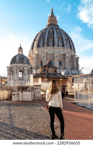 Tourist woman with detailed close up view on Michelangelos Dome of St Peter Basilica in Vatican City, Rome, Lazio, Europe, EU. Architectural masterpiece of Papal Basilica of Saint Peter on sunny day Royalty-Free Stock Photo #2282936635