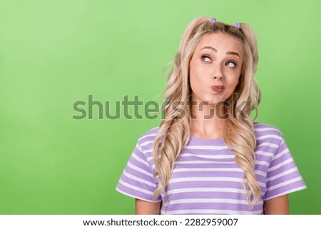 Photo of thoughtful girl with curly hairdo dressed striped t-shirt look empty space planning shopping isolated on green color background Royalty-Free Stock Photo #2282959007