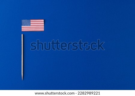 High angle view of flag of united states of america with copy space on blue background. American patriotism, independence day and tradition concept.