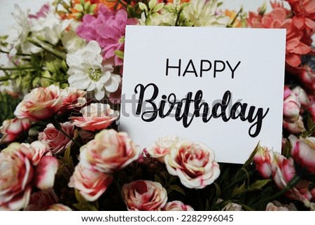 Happy Birthday text message on paper card with beautiful flowers decoration