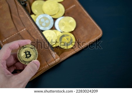 Hand holding cryptocurrency coins on wallet. Bitcoin on wood desk table background. Virtual cryptocurrency concept. digital for defi decentralized financial banking p2p exchange investment technology