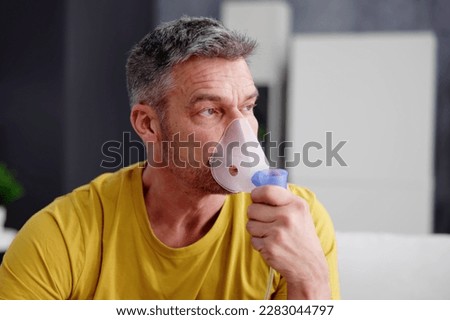 Asthma Patient Breathing Using Oxygen Mask And COPD Nebulizer Royalty-Free Stock Photo #2283044797