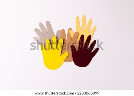 Paper cut out of multi coloured hands with copy space on white background. Humanitarian aid, people, help and human concept.