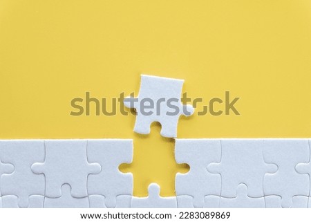 Top view photo of a white jigsaw puzzle over yellow background use for Flat lay top view mock-up item concept.