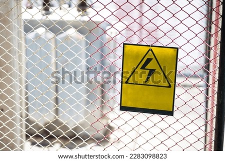 High voltage hazard sign on steel grid in dangerous areas.