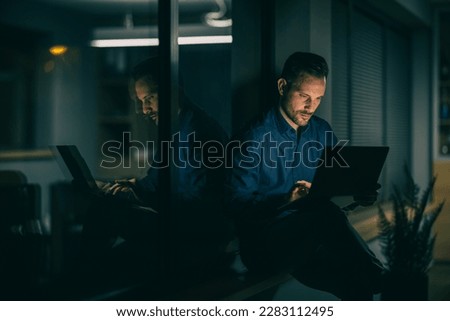 Young stressed businessman working in modern office.Tired man working late in evening.He is feeling sick and tired. Royalty-Free Stock Photo #2283112495