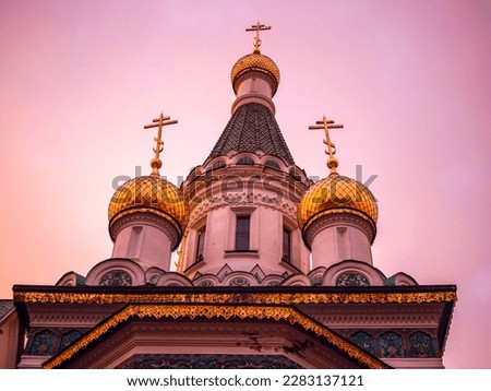 Oppression of Christians and sectarian strife concept. Golden domes of russian Church of St. Nicholas the Wonderworker at dawn isolated in the golden hour Royalty-Free Stock Photo #2283137121