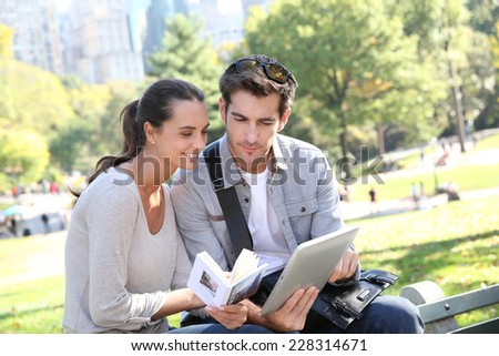 Couple of tourists looking at traveler's guide in Central Park
