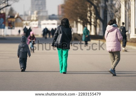 Small children walk in the spring sunny park. Time for leisure and walking with family. Concept. Beautiful picture. Street photography