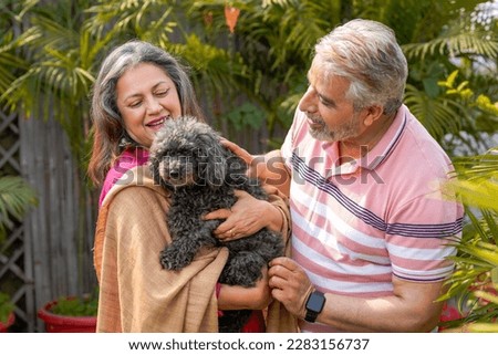 Senior couple loving with dogy puppy. concept about pets and animals. Royalty-Free Stock Photo #2283156737