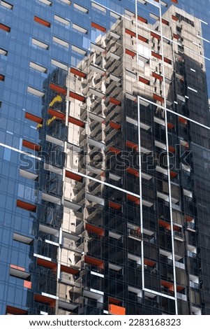 A tower block is mirrored in the glass facade of another building in Melbourne's CBD, Australia