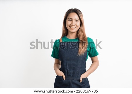 Cheerful young pretty asian woman green t-shirt and apron coffee owner isolated on white background. looking camera. Royalty-Free Stock Photo #2283169735