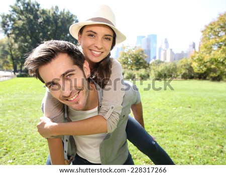 Man giving piggyback ride to girlfriend in Central Park