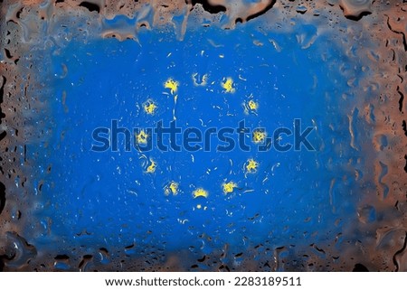 EU flag. European Union flag on the background of water drops. Flag with raindrops. Splashes on glass. Abstract background