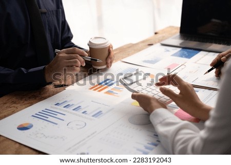 Business team together to make investment plan at the meeting. Close-up of business advisor pointing to graph and chart analyzing company financial report.