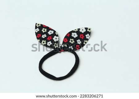 Black cloth hair tie with butterfly motif and floral ornament isolated on white background