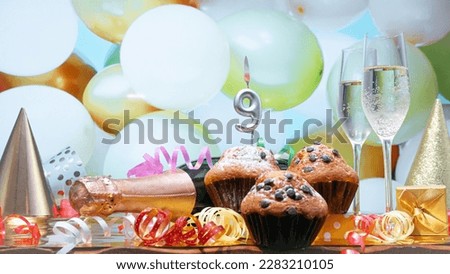 Happy birthday champagne background with number of candles  9. Beautiful congratulations copy space for anniversary.
Festive decorations with a bottle of champagne in pastel colors.