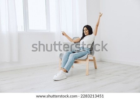 Woman relaxing at home and sipping her hands sitting in a chair with her laptop, lifestyle homemade spirits. Mockup, free copy space