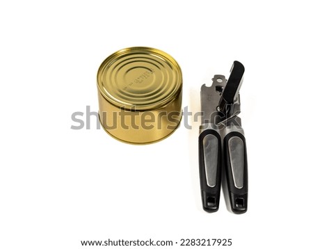 Can opener with tin can isolated on white background. Metal can opener. Close-up.
