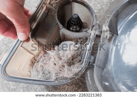 A pile of dust and debris in the dust container from the vacuum cleaner. Dusty pile of plastic garbage bins full of garbage. Selective focus. Royalty-Free Stock Photo #2283221383