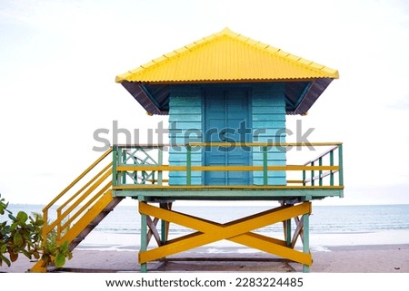 buildings or huts by the beach made in bright colors against the ocean as a backdrop