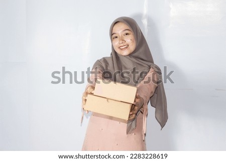Asian hijab woman with gift box, portrait of happy smiling girl holding surprise present