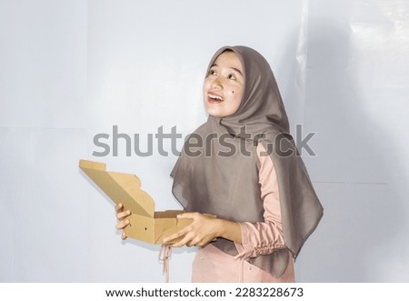 Asian hijab woman with gift box, portrait of happy smiling girl holding surprise present