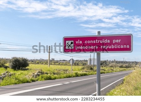 Sign written in Catalan explaining that road was built by Republican prisoners during Franco's regime, after the Spanish Civil War. Santanyi, island of Mallorca, Spain Royalty-Free Stock Photo #2283234455