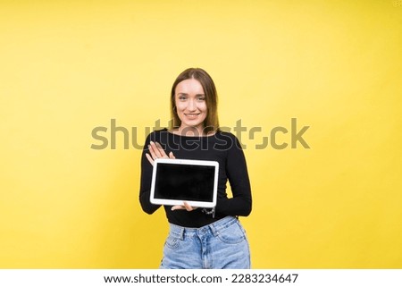 Smart intelligent caucasian young woman student using digital tablet isolated over yellow background