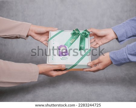 Close up of a set of gift boxes hold by two girl. An Eid celebration gift and giveaways. Royalty-Free Stock Photo #2283244725