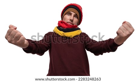 He holds his arms outstretched towards the camera and clenches his fists. A man in colored warm clothes on a white background. Royalty-Free Stock Photo #2283248263