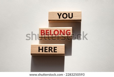 You belong here symbol. Wooden blocks with words You belong here. Beautiful white background. Business and You belong here concept. Copy space.