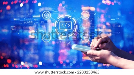 Web development concept with person using a smartphone in a city at night