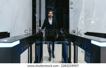 Businessman using card to open automatic gate machine in office building. Male using smart card to open automatic gate machine in office building. Working routine concept. Royalty-Free Stock Photo #2283258907