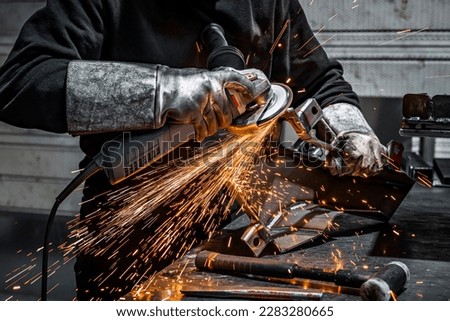 View of worker grinding a piece of metal, France Royalty-Free Stock Photo #2283280665