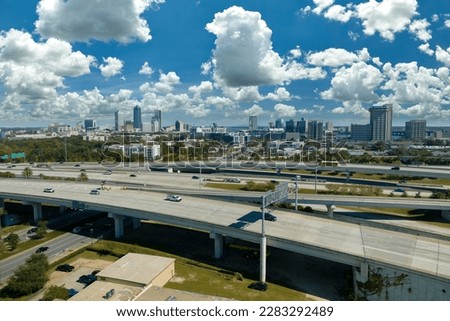 Aerial view of Jacksonville city with high office buildings and american freeway intersection with fast moving cars and trucks. USA transportation infrastructure concept