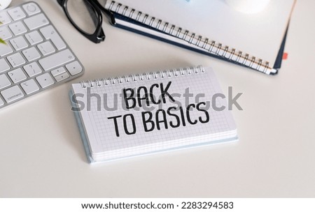 Back to Basics two notepads with text on a white background next to a keyboard and a potted plant