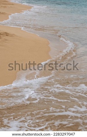 Golden sand at the beach, with soft touch of a calm waves of the Atlantic ocean. Parque Natural Dunas de Corralejo, Fuerteventura, Spain. Royalty-Free Stock Photo #2283297047
