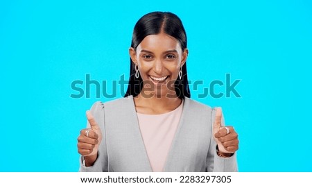 Thumbs up, happy and studio woman with business emoji gesture for congratulations, job well done or winner satisfaction. Agreement, female portrait and person dancing with yes sign on blue background