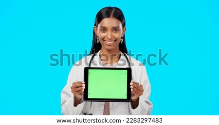 Tablet, green screen and doctor face isolated on blue background telehealth, medical or service software app. Healthcare professional or indian person on digital technology, studio and mockup space