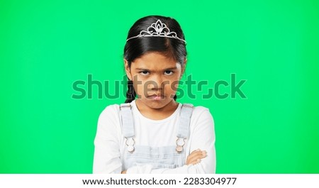 Angry, upset and child with crossed arms on green screen with crown, princess costume and tutu in studio. Portrait, behavior mockup and isolated young girl with anger, disappointed and mad expression