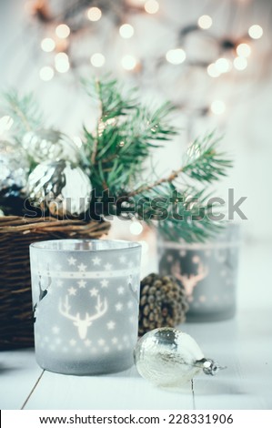 Vintage Christmas decor, old Christmas decorations in a basket, lanterns, garlands and spruce branches on a white table.