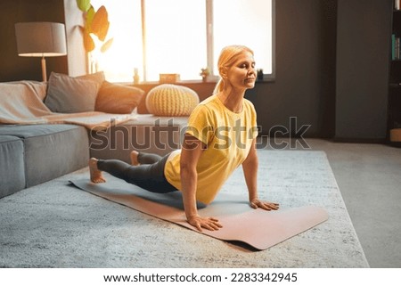 Beautiful athletic adult woman doing asana in yoga. Home training. Royalty-Free Stock Photo #2283342945
