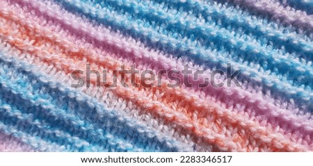 Pink and blue garter stitch knitwear (macro, top view, diagonal, texture).