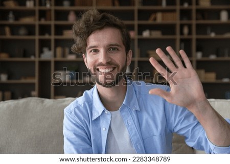 Cheerful handsome young freelance employee man video conference call screen portrait. Happy millennial guy looking at camera, smiling, laughing, waving hand hello. Home head shot Royalty-Free Stock Photo #2283348789