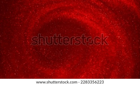A swirl of gold particles in red liquid. A mesmerizing image of gold particles swirling against a red fluid background with a depth of field. Abstract glittering background. Royalty-Free Stock Photo #2283356223