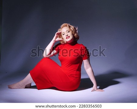 Blonde girl with short hairstyle wavy hair and red lipstick in red clothes retro look 50s-60s