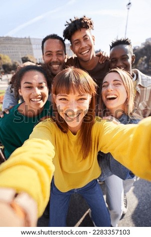 Vertical photo of a Group of happy friends posing for a selfie on a spring day as they party together outdoors. Group of multicultural friends having a good time together on the weekend. Royalty-Free Stock Photo #2283357103